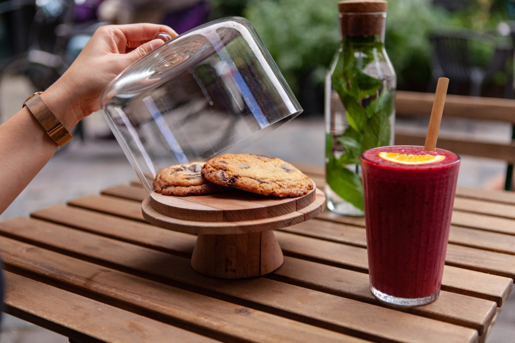 Petite table avec des cookies, une carafe d'eau et un jus de fruit