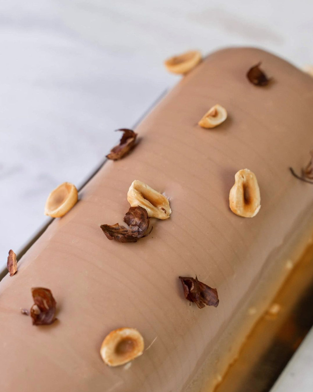 Bûche la Nuts : Un biscuit noisette, un crémeux caramel, du caramel et une ganache montée à partir de fève de Tonka